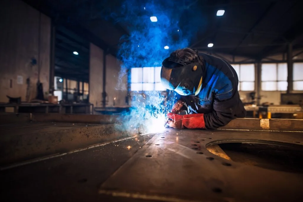 Trabalhador realizando manutenção industrial em estrutura metálica